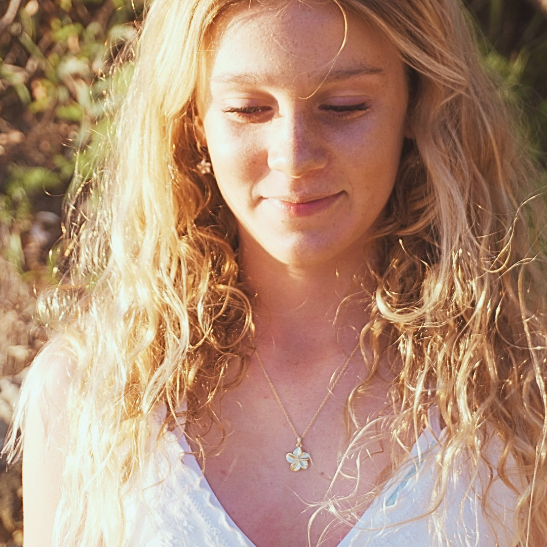 Surf girl wearing Tahiti waterproof gold frangipani necklace at beach - Kailumea
