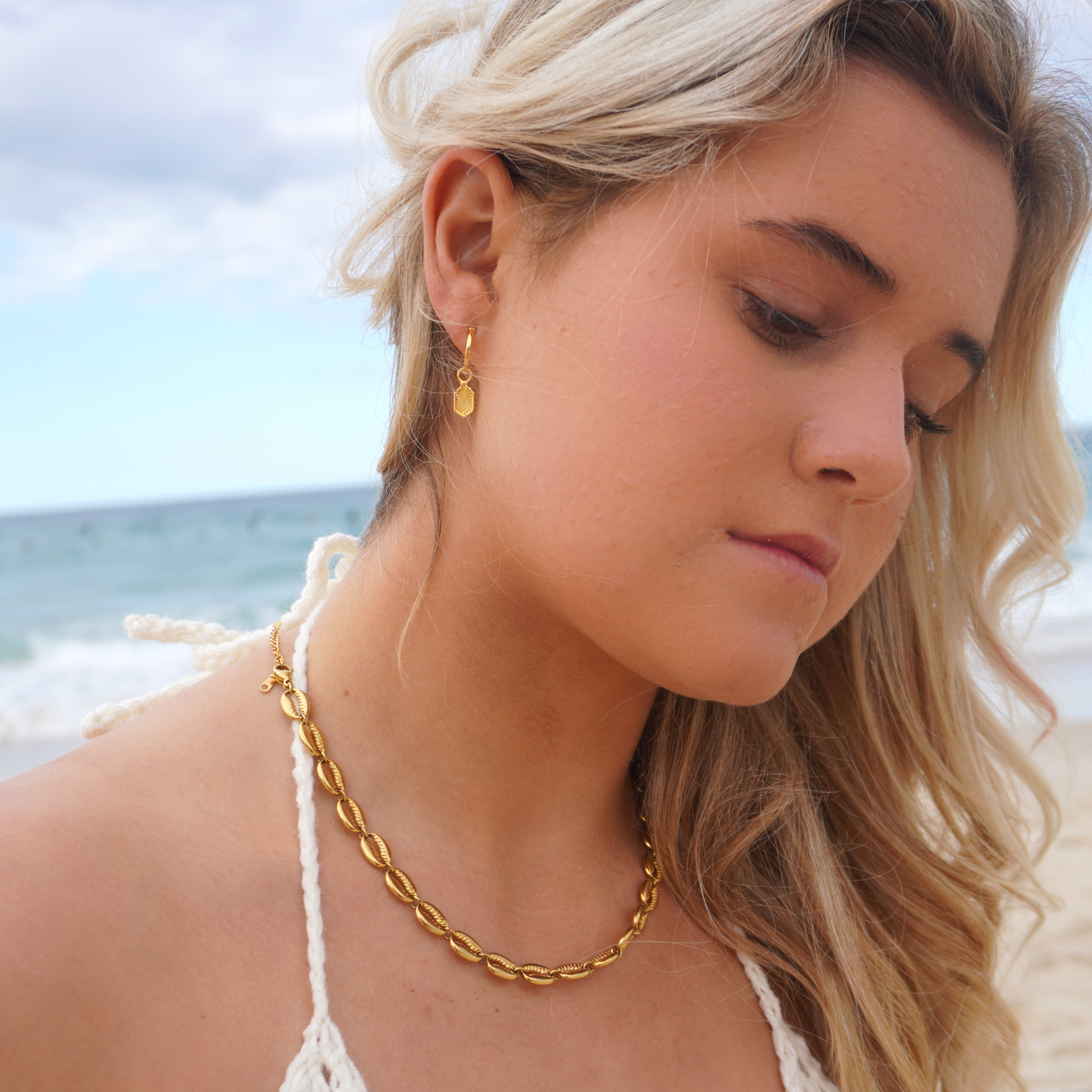 Close up in ear woman wearing Waterproof Manea Gold Boho Pendant Hoop Earrings at beach Kailumea