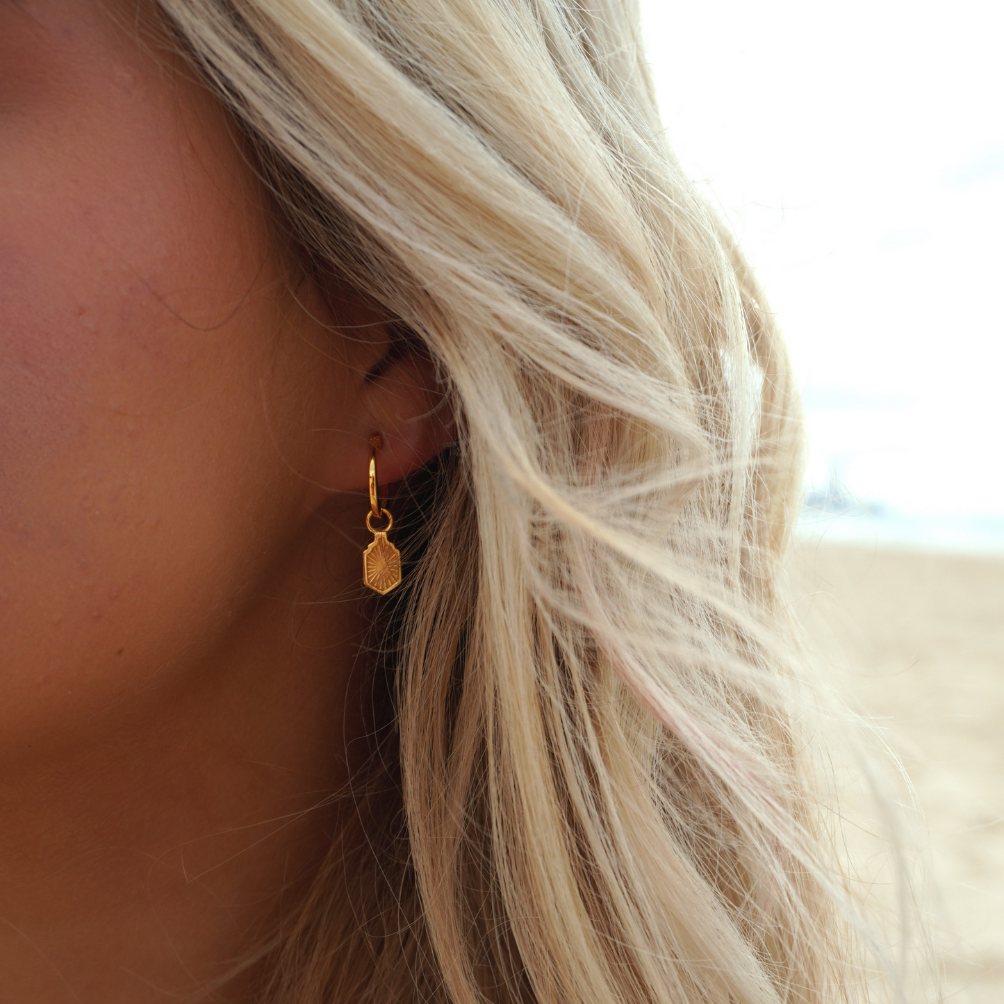 Close up in ear woman wearing Waterproof Manea Gold Boho Pendant Hoop Earrings at beach Kailumea