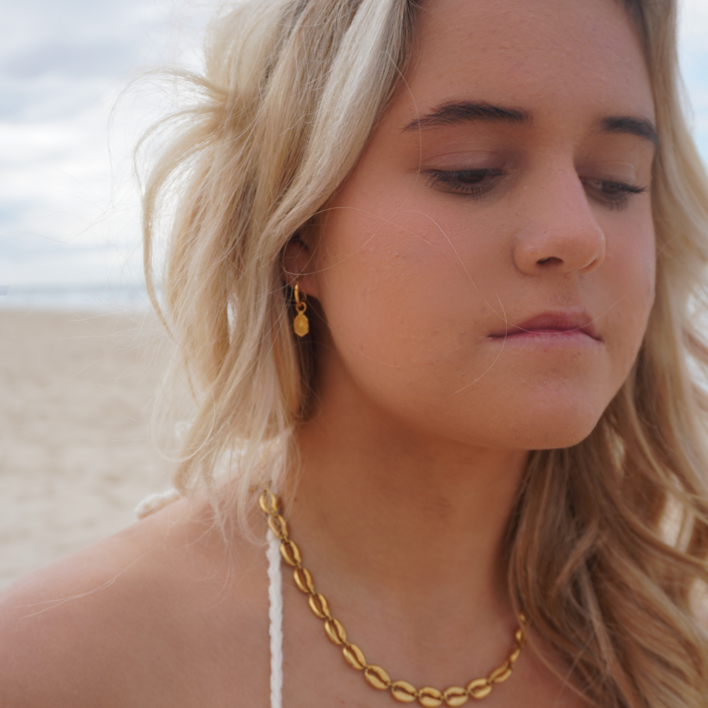 Close up in ear woman wearing Waterproof Manea Gold Boho Pendant Hoop Earrings at beach Kailumea