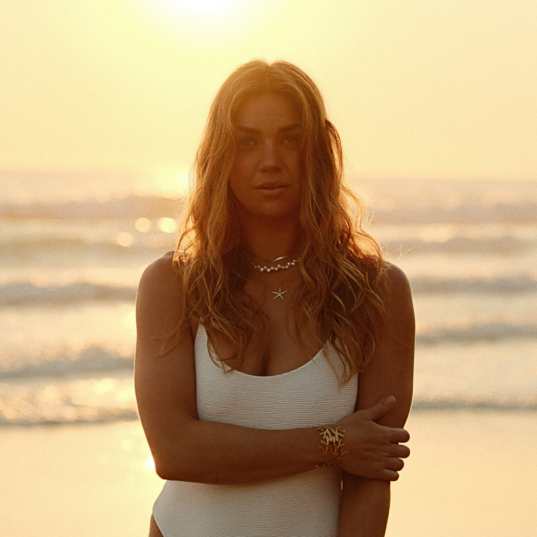 Woman wearing santorini starfish necklace at beach-Kailumea. Stacked with Luna Tide necklace- ocean ready