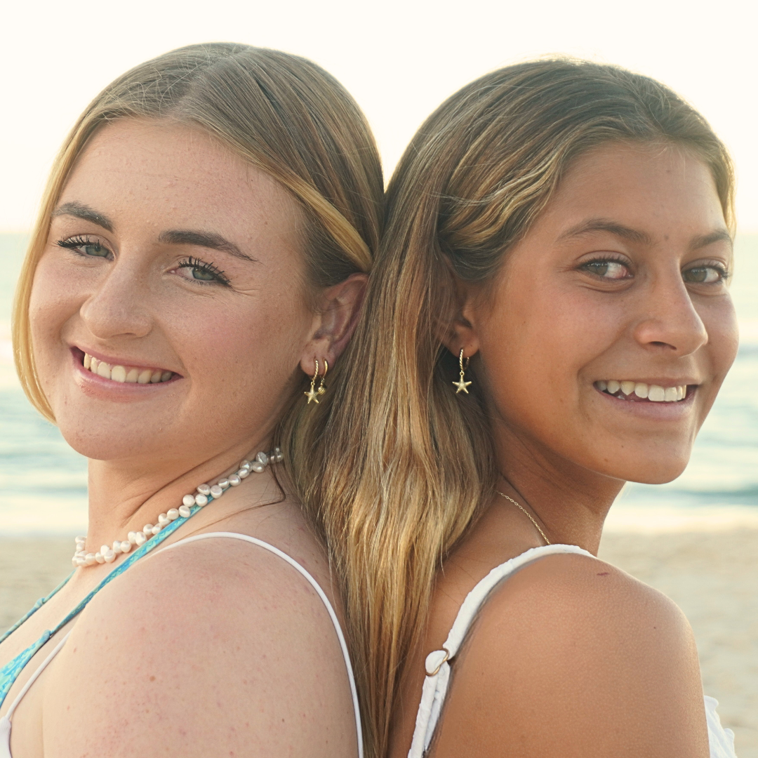 two surf girls wearing Seastar starfish Gold Pendant Earrings at beach. Waterproof Kailumea