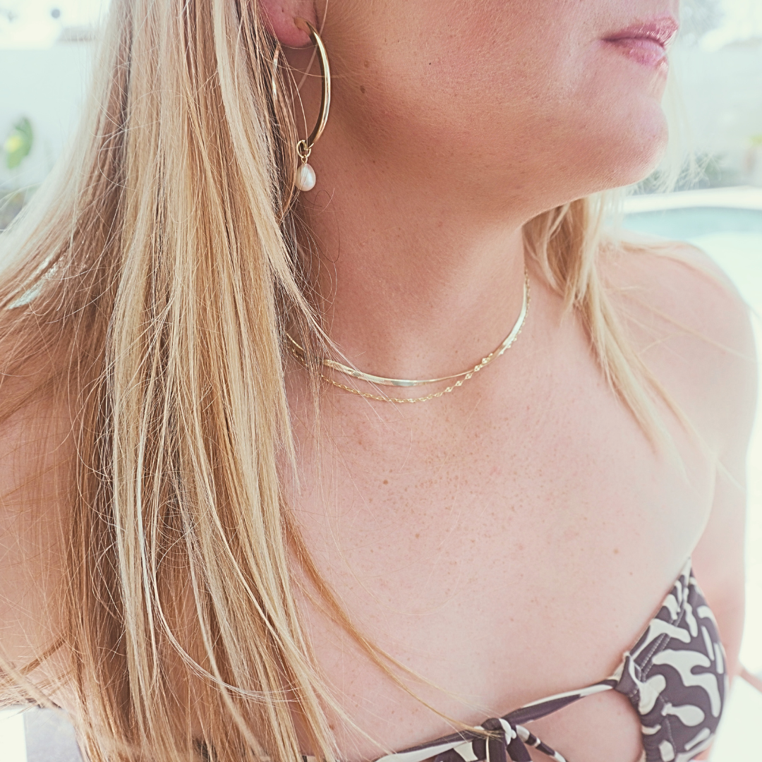 Woman wearing Zephyr Herringbone chain stacked with Mimi sparkle chain and Waikiki Hoops. waterproof gold Kailumea