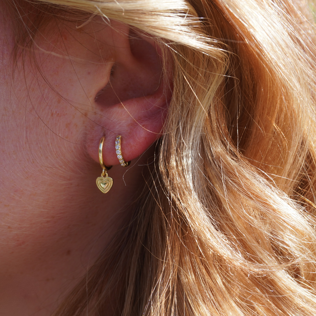 Close up in ear woman wearing Kalinda Huggie CZ Hoop Earrings and chloe heart earrings waterproof Kailumea