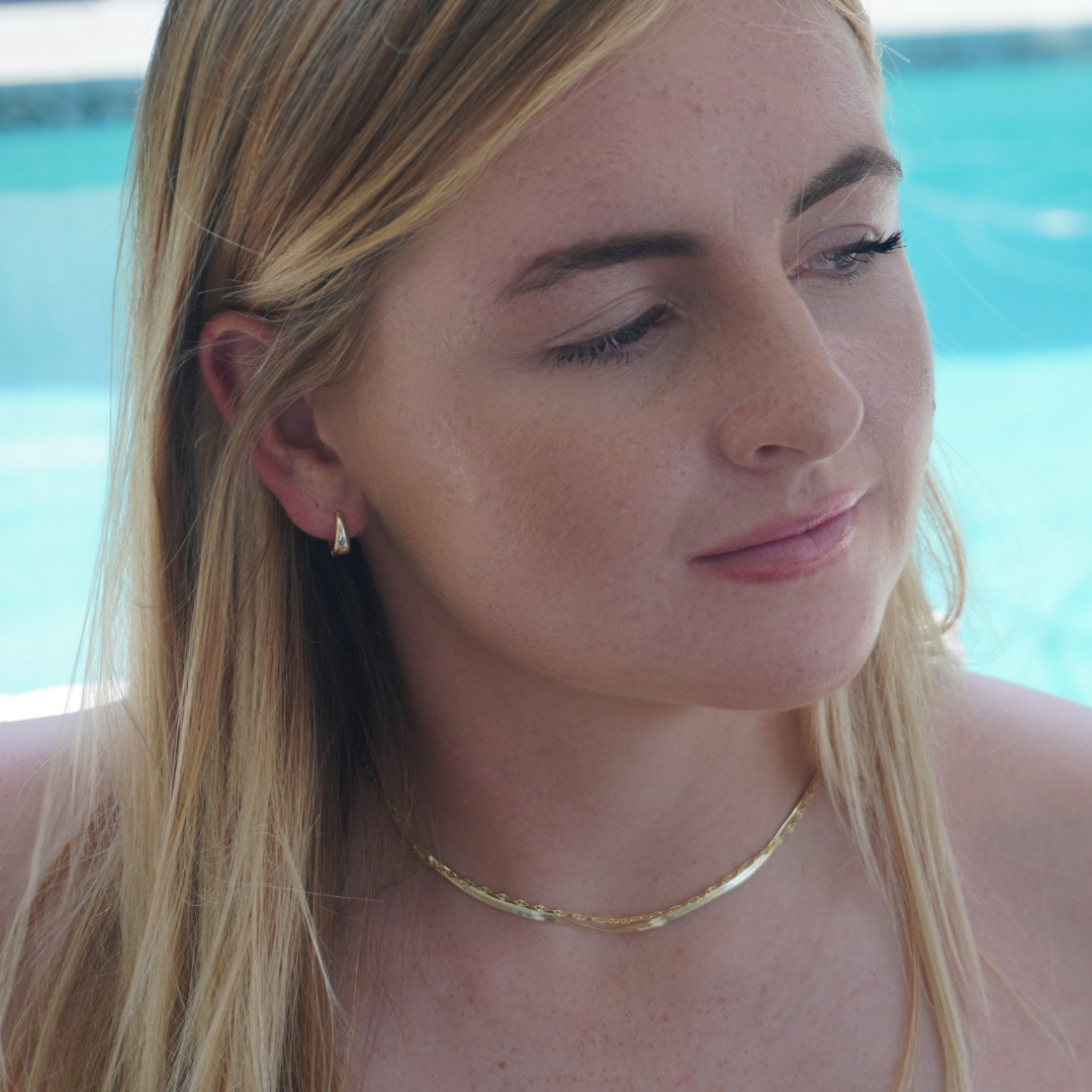Close up in ear woman wearing Waterproof Gold Chunky Small Round Hoops and Sea star Stud earrings and Zephyr and Mimi sparkle chain Kailumea