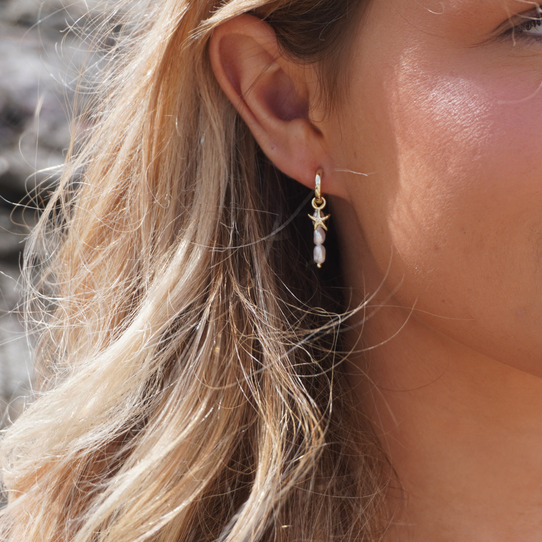 Close up in ear woman wearing Selene Starfish Pearl String hoop earrings and starfish studs waterproof Kailumea