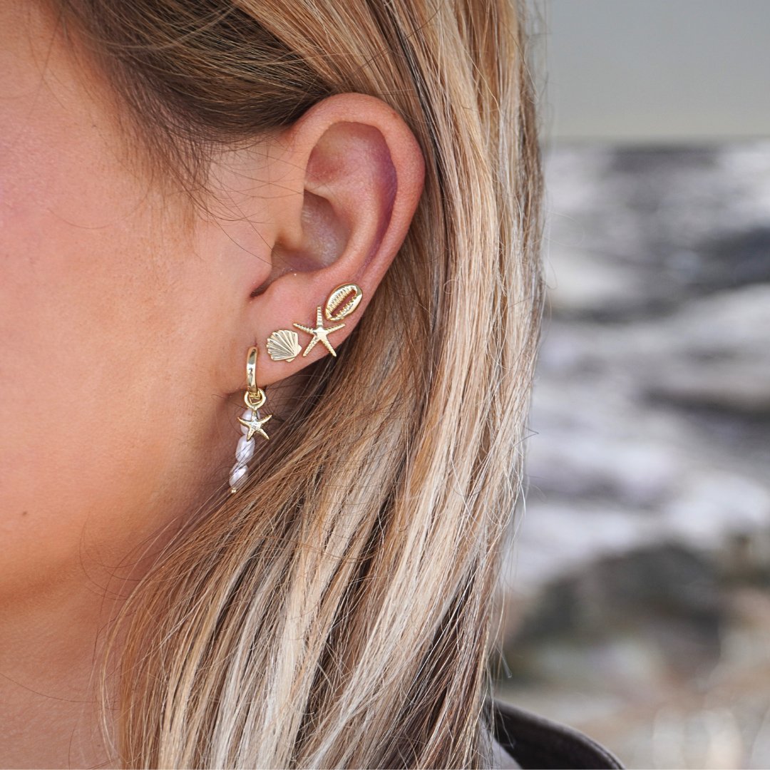 Close up in ear woman wearing Selene Starfish Pearl String hoop earrings stacked with starfish studs shell studs cowrie studs waterproof Kailumea