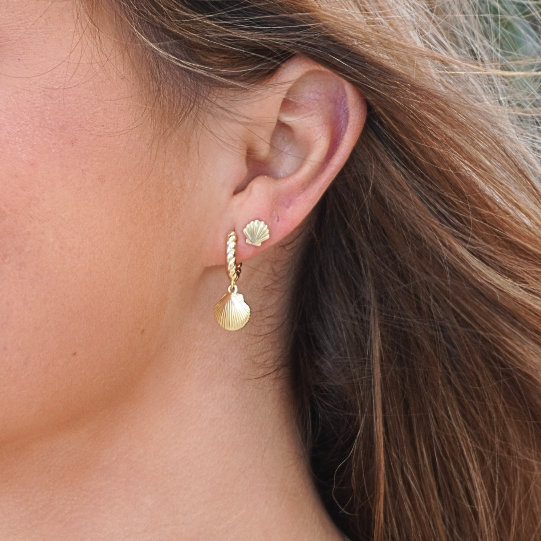 on ear close-up woman wearing Iluka Gold shell hoops and shell stud earrings . waterproof ocean-safe Kailumea